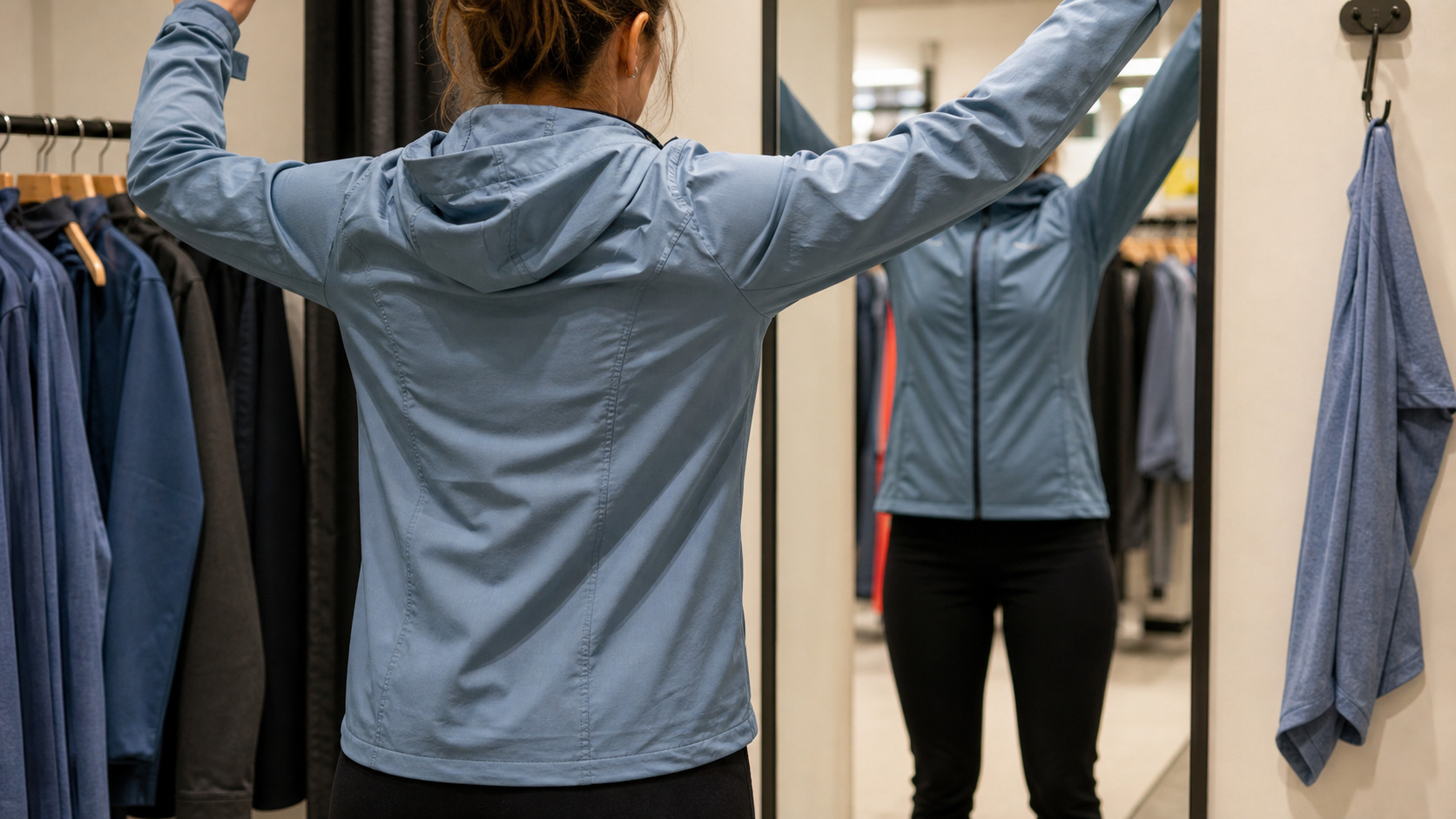 Essayage d'une veste de sport avec bras levés devant un miroir
